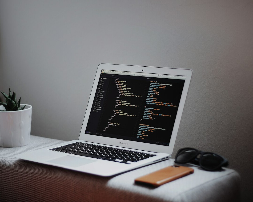 person writing code on laptop
